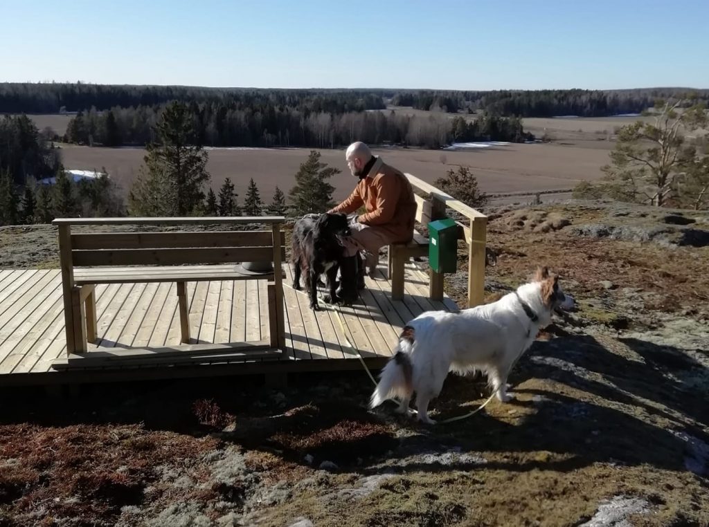 Man and two dogs sitting on top of Linnavuori hill.